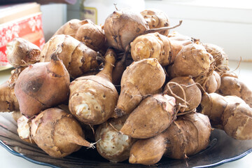 black plate with fresh Jerusalem artichoke close-up