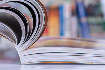 Opened book with blur bookshelves in background