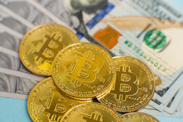Close up of golden bitcoins on a background of dollars. Cryptocurrency. Finance and business. 