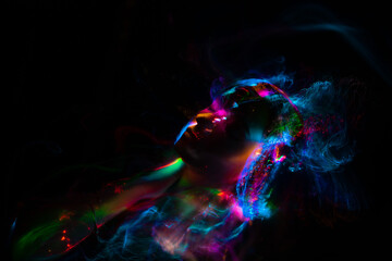 Portrait of a beautiful woman in colored beams of a projector. Streaks of light and shadow on the skin.