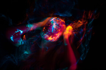Portrait of a beautiful woman in colored beams of a projector. Streaks of light and shadow on the...