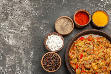 top view roasted eggplant salad in bowl different spices in bowls on dark background free space