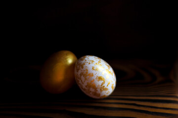 Golden Eggs on dark wooden background. A background for celebrating Easter Top view and copy space Flatlay. Dark background and Minimal black trend 2020. Generous accommodation for copy space.