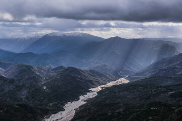 Arachthos river in Tzoumerka mountain range, sunbeams through the clouds