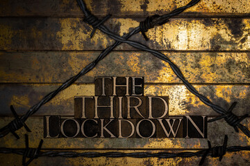 The Third Lockdown text on grunge textured copper and gold background enclosed by barbed wire