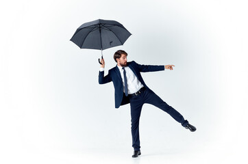 a gentleman with an open umbrella in a dark suit bent to the side