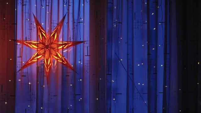 Decorative Bethlehem red seven-pointed star in the window at dusk during Christmas.
