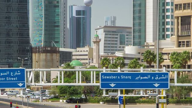 Kuwait City skyline with skyscrapers timelapse in downtown. View from bridge with traffic on the road. Kuwait City, Middle East.