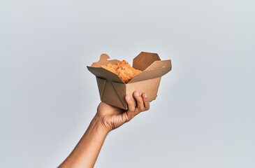 Hand of hispanic man holding fried chicken over isolated white background.