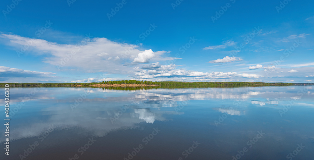 Wall mural panorama of calm lake, kama river blue sky with clouds reflected in the water.