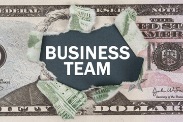 The dollar is torn in the center. In the center it is written - BUSINESS TEAM