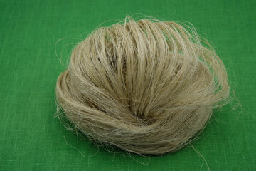 Fibers of natural uncolored flax or hemp, tow, close-up. Green canvas. Flax or hemp processing concept. Growing demand for natural fibers.