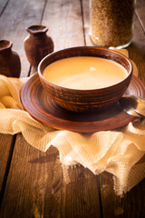soup of buckwheat with milk in a ceramic bowl on rustic table