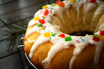 Bundt cake with white glaze on dark rustic background