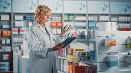 Pharmacy Drugstore: Mature Experienced Female Farmacist Uses Digital Tablet Computer to Arrange,...