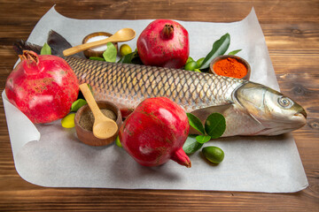 front view fresh fish with pomegranates on brown desk raw seafood ocean animal