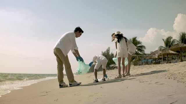 Volunteer  family collects garbage plastic trash waste bottles 