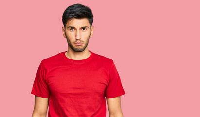 Obraz premium Young handsome man wearing casual red tshirt depressed and worry for distress, crying angry and afraid. sad expression.