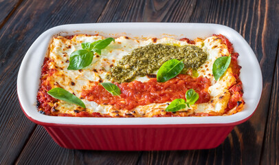 Lasagne topped with tomato sauce and pesto