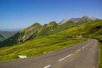  Mountain road surrounded by green meadows through the French Pyrenees. High quality photo. Copy Space for characters or letters