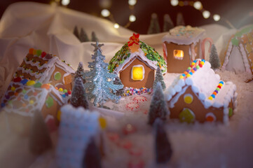 Gingerbread House Village under the twinkling star lights, Bokeh, dark night with warm light