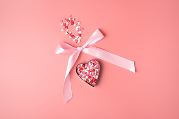 Romantic background with heart bow on pink background. The view from the top. The concept of...