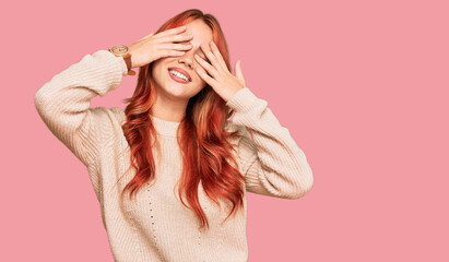 Young redhead woman wearing casual winter sweater covering eyes with hands smiling cheerful and funny. blind concept.