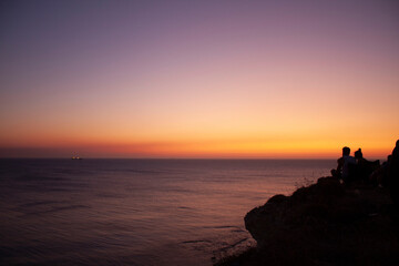 people watching the amazing sunset on the hill