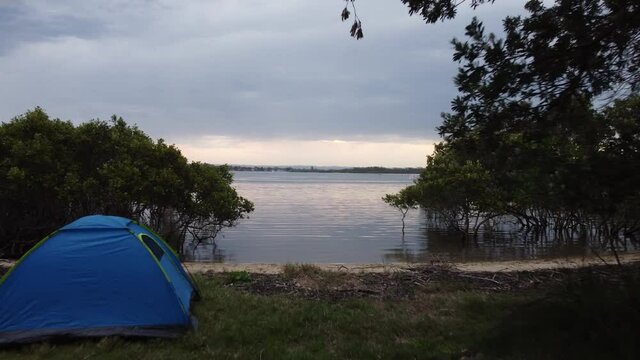 Camping with blue tent near a lake