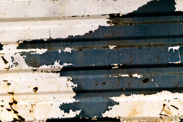 The texture of the old metal sheet. Peeling paint on the metal profile. Rust on a metal sheet.