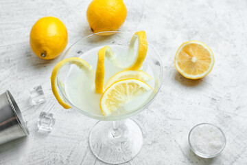 Glass of tasty martini on light background