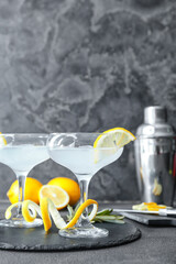Glasses of tasty martini with lemon on grunge background
