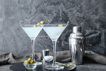 Glasses of tasty martini on dark background