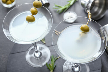 Glasses of tasty martini on dark background