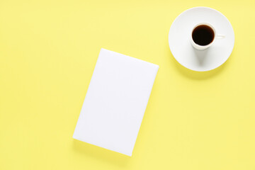Blank book and cup of coffee on color background