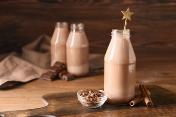 Bottle of aromatic chocolate milk on wooden background