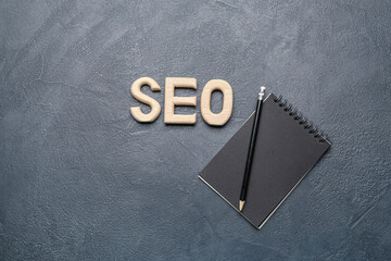 Abbreviation SEO with notebook and pencil on dark background