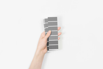 Color swatches with color of the year 2021 in the hand - Ultimate Grey. 