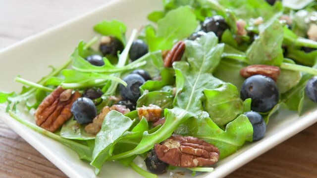 Panning our of a Mixed Green Salad with Blueberries and Pecans