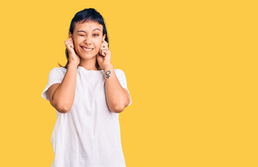 Young woman wearing casual clothes covering ears with fingers with annoyed expression for the noise of loud music. deaf concept.