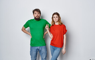 Obraz premium cheerful young couple in colorful t-shirts emotions studio lifestyle isolated background