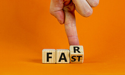 Alone and fast or together and far. Male hand turns cubes and changes the word 'fast' to 'far' on a beautiful orange background. Business and fast or far concept. Copy space.