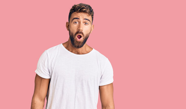Young hispanic man wearing casual white tshirt afraid and shocked with surprise expression, fear and excited face.