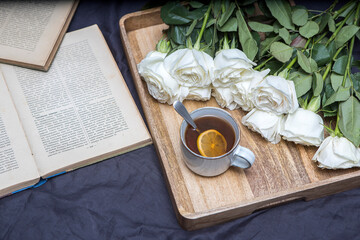 Roses Playa blanca is with cup of tea with lemon on the wooden tray on the grey shirt.