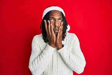 African american man with braids wearing christmas hat tired hands covering face, depression and sadness, upset and irritated for problem