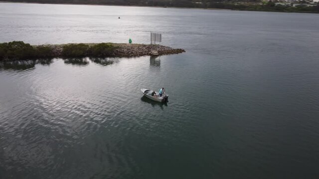 Drone circling around a boat with people fishing on it