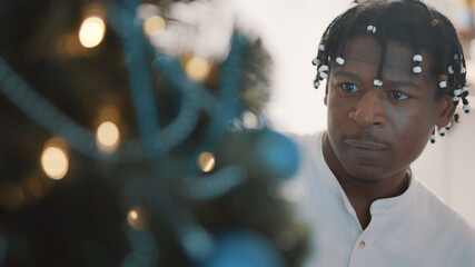 Young african american black man decorating the christmas tree, Close up. High quality photo