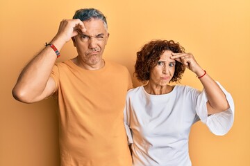 Beautiful middle age couple together wearing casual clothes worried and stressed about a problem with hand on forehead, nervous and anxious for crisis