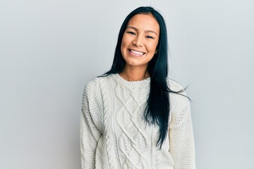 Beautiful hispanic woman wearing casual winter sweater over white background with a happy and cool...
