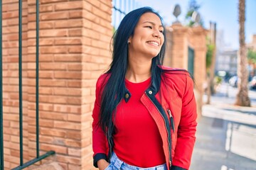 Young latin woman smiling happy walking at the city.